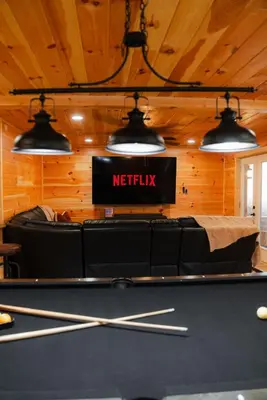 a pool table in a room with a netflix sign at Sleeps 16 Luxury Cabin with Game Room & Hot Tub in Logan
