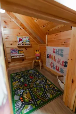 a small room with a rug in a wooden cabin at Sleeps 16 Luxury Cabin with Game Room & Hot Tub in Logan