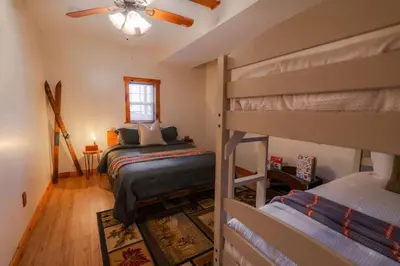 a bedroom with two bunk beds and a ceiling fan at COZY Cabin with Hot Tub - Near all in Hocking Hills in Logan