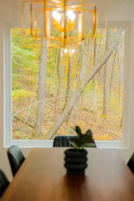 a dining room table with a view of a window at The Greenhouse with Indoor Slide close to Hocking Hills in South Bloomingville