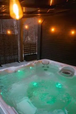 a jacuzzi tub with green lights in a room at The Greenhouse with Indoor Slide close to Hocking Hills in South Bloomingville