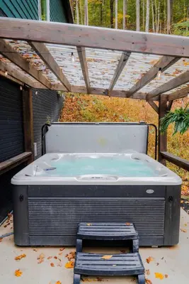 a hot tub sitting under a pergola at The Greenhouse with Indoor Slide close to Hocking Hills in South Bloomingville