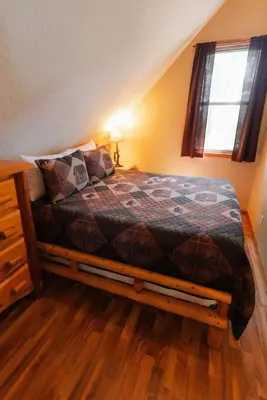 a bedroom with a bed and a window at Cheerful Two Bdrm Cabin with Hot Tub & Pet Friendly in Rockbridge
