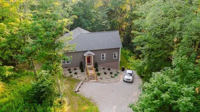 an aerial view of a house with a car parked in a driveway at Modern 2 BD cabin with hot tub & Games & Central Loc in Rockbridge