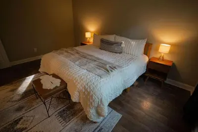 a bedroom with a large bed and two lamps at Modern 2 BD cabin with hot tub & Games & Central Loc in Rockbridge