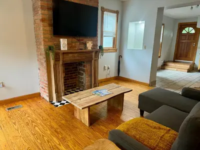 a living room with a fireplace and a flat screen tv at Jungle House Luxury Stays - Columbus Downtown Short North in Columbus