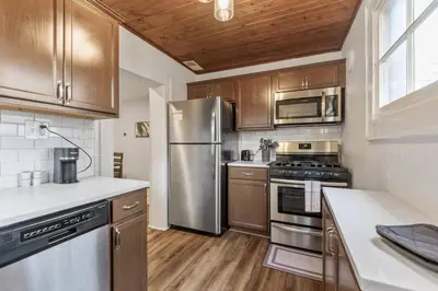a kitchen with stainless steel appliances and wooden cabinets at Entire Duplex - 2 Units in Columbus