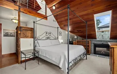 a bedroom with a canopy bed and a fireplace at Waterfront Luxury Family Retreat in Sandusky