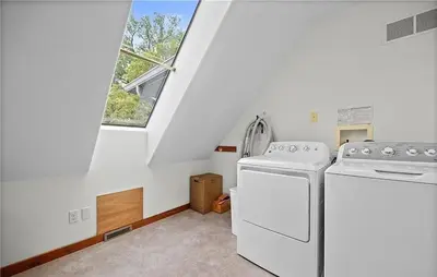 a laundry room with two washing machines and a window at Waterfront Luxury Family Retreat in Sandusky