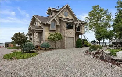a house with a gravel driveway in front of it at Waterfront Luxury Family Retreat in Sandusky