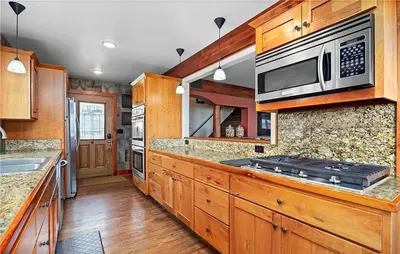 a kitchen with wooden cabinets and a stove top oven at Waterfront Luxury Family Retreat in Sandusky