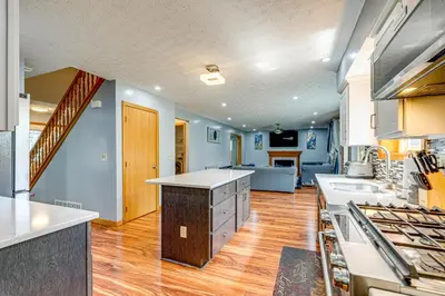 a large kitchen with wooden floors and blue walls at Families Welcome Lake-View Home, 2 Mi to Gahanna! in Columbus