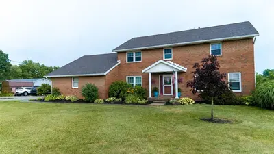 a brick house with a tree in the yard at The Estate on 68 AND Pet Friendly in Springfield