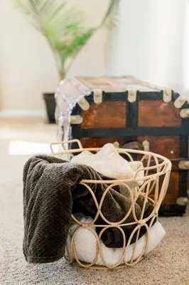 a basket of towels on the floor next to a chest at The Estate on 68 AND Pet Friendly in Springfield