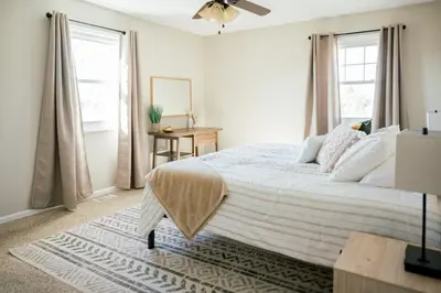 a bedroom with a bed and a table and windows at The Estate on 68 AND Pet Friendly in Springfield