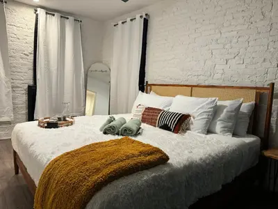 a bedroom with a large white bed with pillows at Jungle House Columbus Downtown Free Parking Sleeps 8 - Steps to Convention Center & Nationwide Arena - 2BR Short North Luxury Home - Over 5,800 Five Star Stays in Columbus