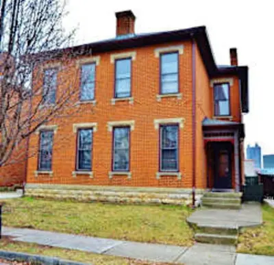 a large orange brick house with a front door at Jungle House Columbus Downtown Free Parking Sleeps 8 - Steps to Convention Center & Nationwide Arena - 2BR Short North Luxury Home - Over 5,800 Five Star Stays in Columbus