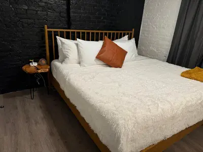 a bed with white sheets and pillows on it at Jungle House Columbus Downtown Free Parking Sleeps 8 - Steps to Convention Center & Nationwide Arena - 2BR Short North Luxury Home - Over 5,800 Five Star Stays in Columbus