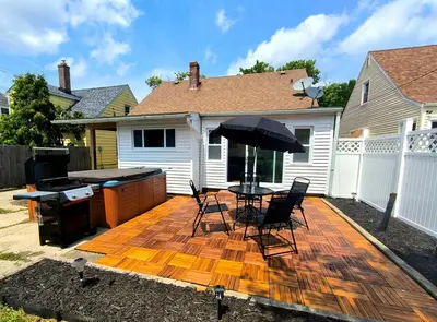 a patio with a table and chairs and an umbrella at South Euclid 4BR Luxe Escape with Game room and BBQ in South Euclid