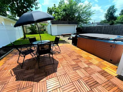 a patio with a table and chairs and an umbrella at South Euclid 4BR Luxe Escape with Game room and BBQ in South Euclid