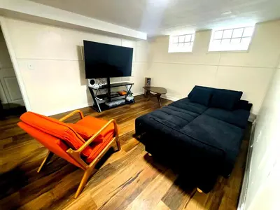a living room with a couch and a tv at South Euclid 4BR Luxe Escape with Game room and BBQ in South Euclid