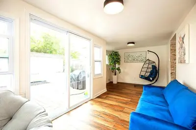 a living room with a blue couch and a large window at South Euclid 4BR Luxe Escape with Game room and BBQ in South Euclid