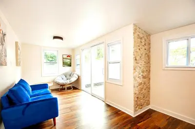 a living room with a blue couch and windows at South Euclid 4BR Luxe Escape with Game room and BBQ in South Euclid
