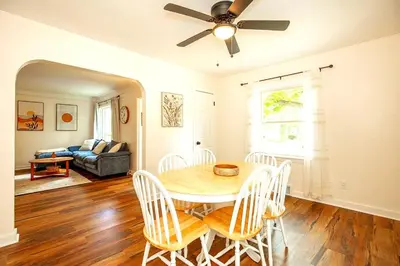 a dining room with a table and chairs and a couch at South Euclid 4BR Luxe Escape with Game room and BBQ in South Euclid