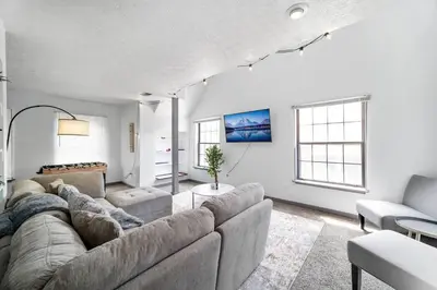 a living room with a large couch and two chairs at Collins Avenue Duplex – 2 Homes in Columbus