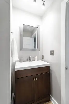 a bathroom with a sink and a mirror at Collins Avenue Duplex – 2 Homes in Columbus