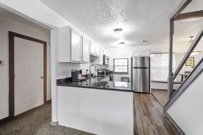a kitchen with white cabinets and a counter top at Collins Avenue Duplex – 2 Homes in Columbus