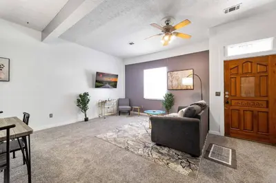 a living room with a couch and a ceiling fan at Collins Avenue Duplex – 2 Homes in Columbus