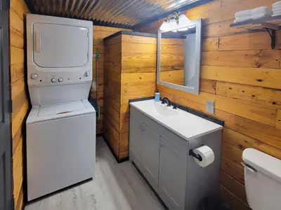 a bathroom with a toilet and a sink and a mirror at Boons Camp Cabin