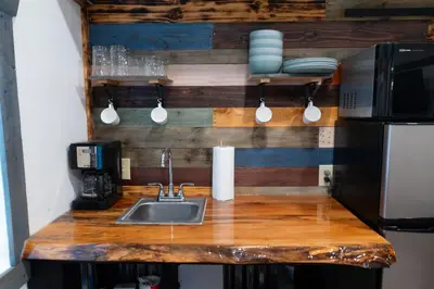 a kitchen counter with a sink and a microwave at Boons Camp Cabin
