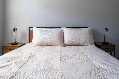 a white bed with two nightstands and two lamps at Cozy 2BR Retreat with Workspace - Washer and Dryer in Kettering