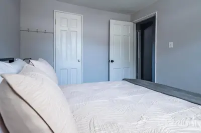 a white bed with white pillows in a bedroom at Cozy 2BR Retreat with Workspace - Washer and Dryer in Kettering