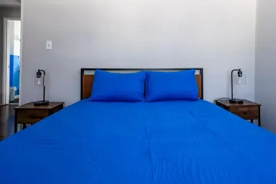 a blue bed with two blue pillows in a bedroom at Cozy 2BR Retreat with Workspace - Washer and Dryer in Kettering