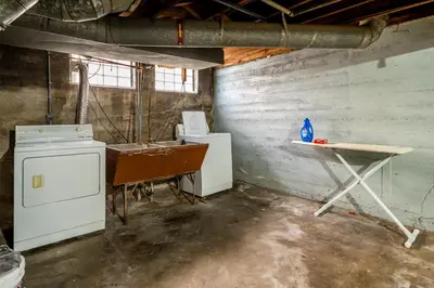 a laundry room with a table and machines in it at Cozy 2BR Retreat with Workspace - Washer and Dryer in Kettering