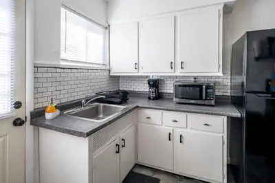 a kitchen with white cabinets and a sink and a microwave at Relaxed 2BR Apt in Moraine with Office Space and Washer & Dryer in Moraine
