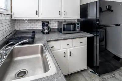 a kitchen with a sink and a refrigerator at Relaxed 2BR Apt in Moraine with Office Space and Washer & Dryer in Moraine