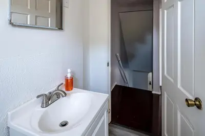 a white bathroom with a sink and a mirror at Relaxed 2BR Apt in Moraine with Office Space and Washer & Dryer in Moraine