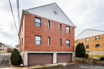 a red brick building with a garage at Paws & Peace Cozy 1BR Ground Flr Gem in Dayton in Dayton