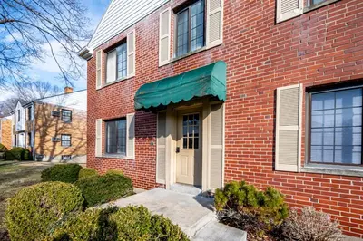 a red brick house with a green awning at Paws & Peace Cozy 1BR Ground Flr Gem in Dayton in Dayton