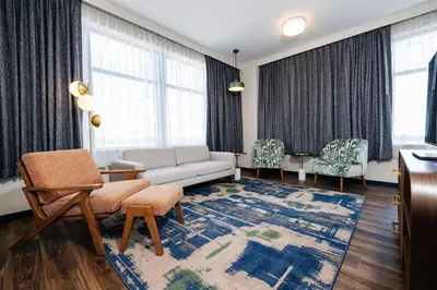 a living room with a couch and chairs and windows at The Hotel Rambler Montgomery, Tapestry Collection By Hilton