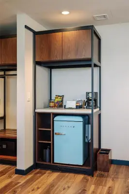 a kitchen with a large glass wall with a refrigerator at The Hotel Rambler Montgomery, Tapestry Collection By Hilton
