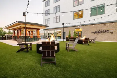 a fire pit in the grass in front of a building at The Hotel Rambler Montgomery, Tapestry Collection By Hilton