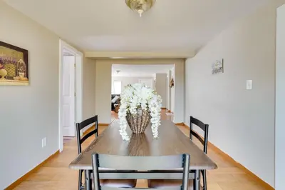 a dining room table with a vase of flowers at Charming and Convenient Home in Butler