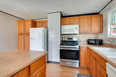 a kitchen with wooden cabinets and a white refrigerator at Charming and Convenient Home in Butler