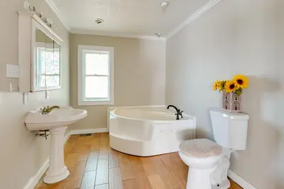 a bathroom with a tub and a sink and a toilet at Charming and Convenient Home in Butler