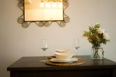 a table with plates and glasses and a vase with flowers at Charming 2 Bedroom Loft in Cleveland